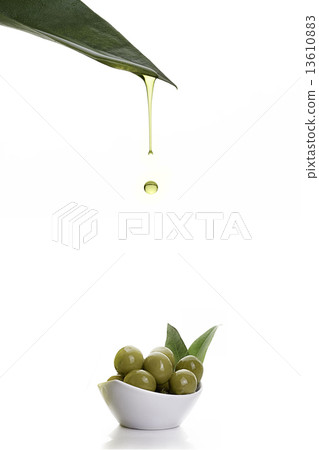 olive oil dripping from a fresh green leaf. Olive seeds 13610883
