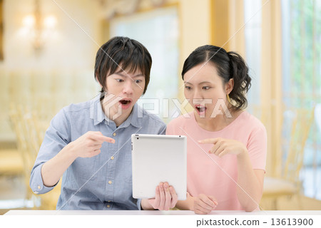 20多歲夫婦誰拿著一台咖啡館的平板電腦 13613900