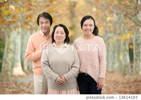 Three family members of parents and daughters who take commemorative pictures at the autumn park Three family members of parents and daughters who take commemorative pictures at the autumn park 13614103