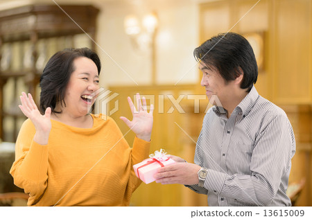 給禮物的中年夫婦在他們的周年紀念的妻子 13615009