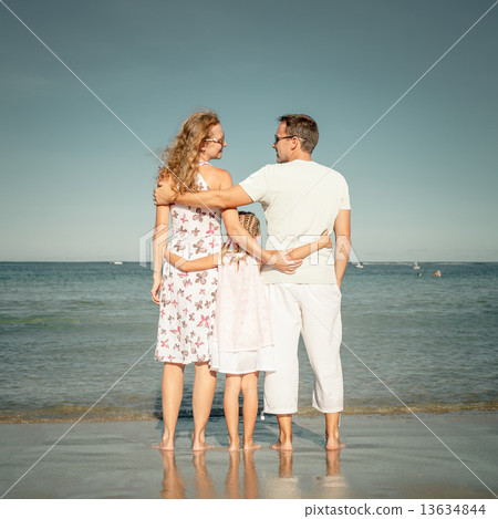 Happy family standing at the beach at the day time 13634844