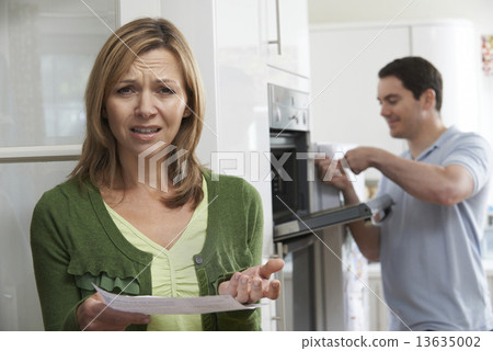 Stock Photo: Unhappy Female Customer With Oven Repair Bill