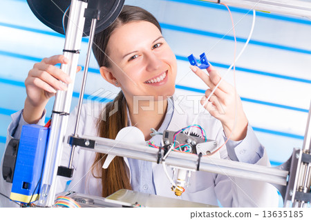 A student girl print prototype on  3D printer 13635185