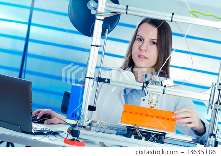 A student girl print prototype on  3D printer 13635186