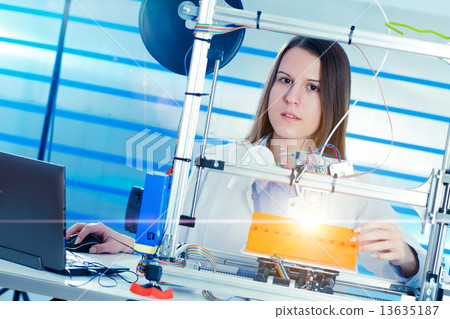 A student girl print prototype on  3D printer 13635187