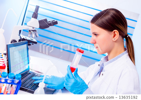 Portrait of pretty girl laboratory assistant analyzing a blood s 13635192