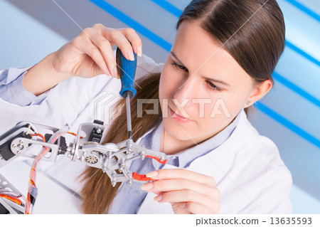 schoolgirl adjusts the robot arm model, girl in a robotics labor schoolgirl adjusts the robot arm model, girl in a robotics labor 13635593