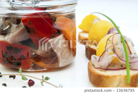 pickled herring in a glass jar with potato canapes pickled herring in a glass jar with potato canapes 13636785