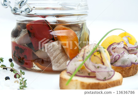 pickled herring in a glass jar with potato canapes 13636786