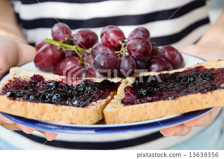 hand holding grape jelly sandwich  13639356
