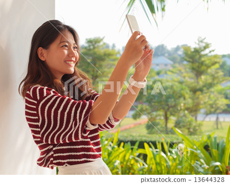 portrait of beautiful woman take a photo, selfie by mobile phone 13644328