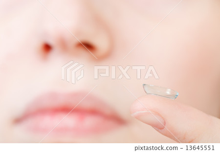 corrective lens on finger near female face corrective lens on finger near female face 13645551
