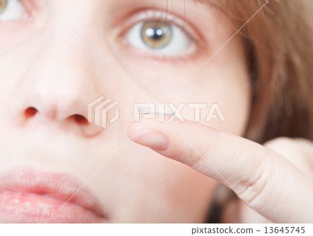 finger with corrective lens and female face finger with corrective lens and female face 13645745