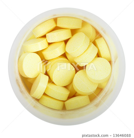 yellow pills in round plastic bottle close up 13646088