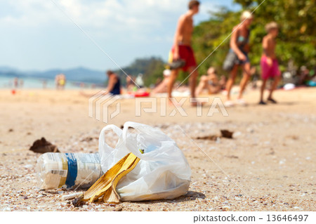Garbage on a beach left by tourists, environmental pollution con 13646497
