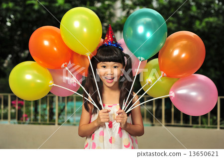 A cute Asian girl is posing with many colourful balloons at her birthday party A cute Asian girl is posing with many colourful balloons at her birthday party 13650621