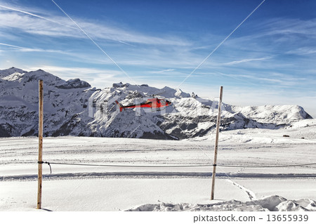 Landing of red helicopter at swiss alpine highland Landing of red helicopter at swiss alpine highland 13655939