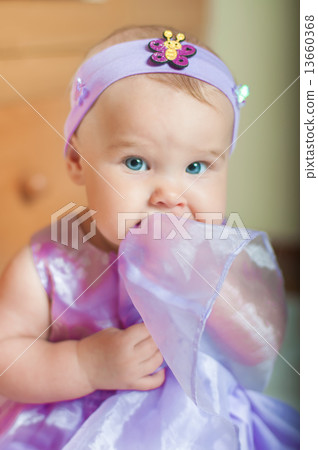 Little girl in a beautiful dress at home smilling 13660368