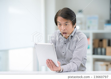 穿著休閒服的中年男性，他們正在室內操縱藥片 13660797