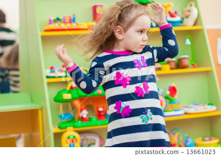 Little girl playing with toys in the playroom Little girl playing with toys in the playroom 13661023