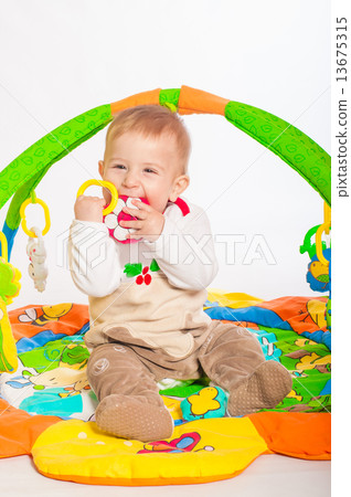 Baby boy playing with colorful toys 13675315