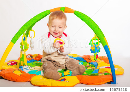 Baby boy playing with colorful toys 13675318