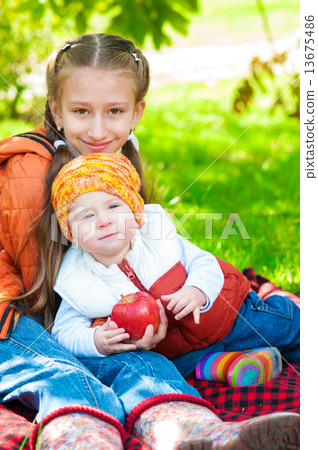 Little girl and little boy in autumn park with apples Little girl and little boy in autumn park with apples 13675486