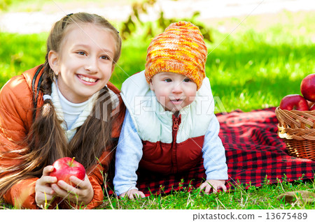 Little girl and little boy in autumn park with apples Little girl and little boy in autumn park with apples 13675489