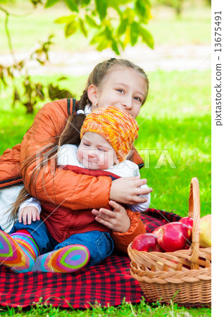 Little girl and little boy in autumn park with apples 13675491