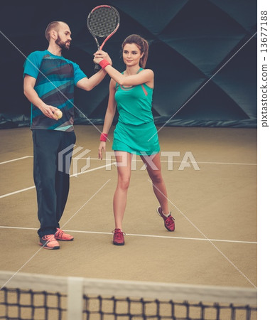 Woman player and her coach practicing on a tennis court 13677188