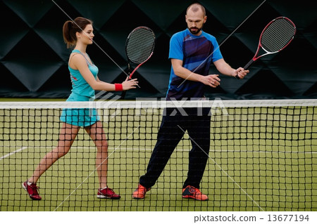 Woman player and her coach practicing on a tennis court 13677194