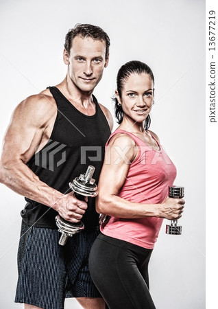 Athletic man and woman with a dumbbells 13677219