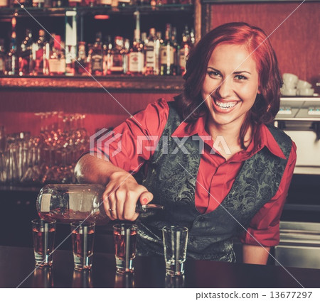 Beautiful redhead barmaid making shots 13677297