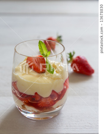 图库照片: vanilla pudding with tipsy strawberries on wood