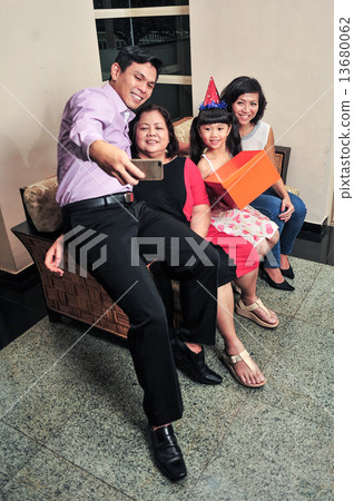 Asian family taking selfie during their daughter's birthday party Asian family taking selfie during their daughter's birthday party 13680062