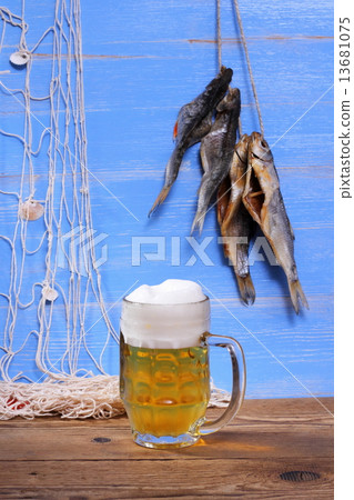 Beer on blue background with dried rudd fish Beer on blue background with dried rudd fish 13681075