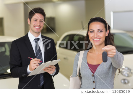 Female driver showing a key after bying a new car 13685059