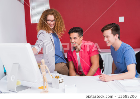 Stock Photo: Smiling students working together on computer