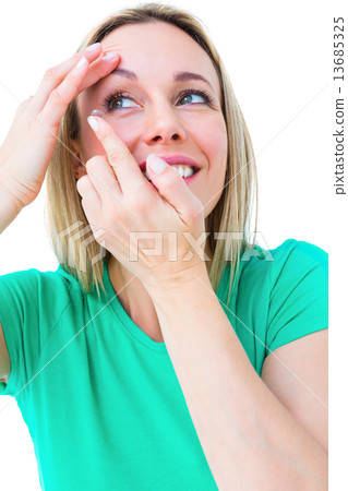 Smiling blonde applying contact lens 13685325