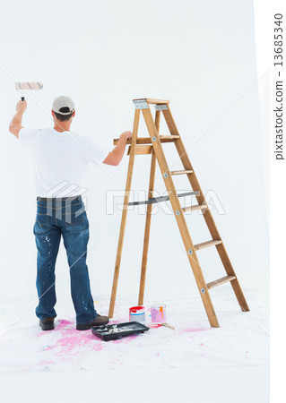 Man painting by step ladder on white background 13685340