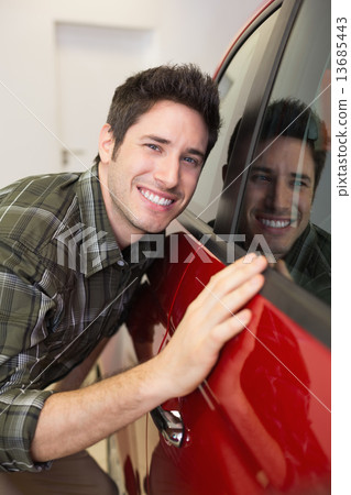 Smiling man hugging a red car Smiling man hugging a red car 13685443