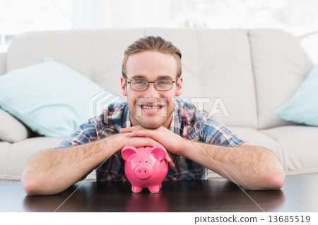 Smiling man with a piggy bank Smiling man with a piggy bank 13685519