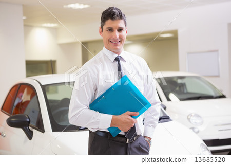 Man standing with hand in pocket while holding folder Man standing with hand in pocket while holding folder 13685520