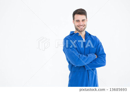 Smiling young male machanic standing arms crossed Smiling young male machanic standing arms crossed 13685693