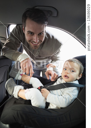 Father securing his baby in the car seat Father securing his baby in the car seat 13686029