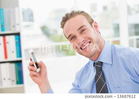 Smiling businessman using smartphone 13687612