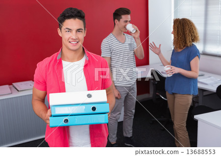 Student holding pile of ring binder near classmates with coffee Student holding pile of ring binder near classmates with coffee 13688553