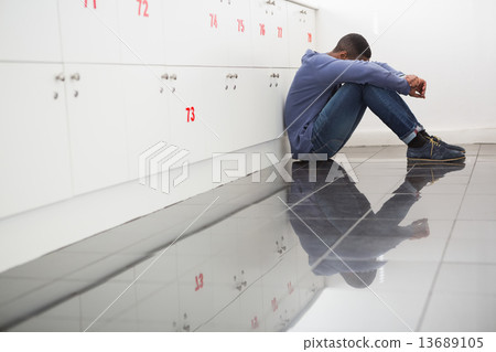 Solitary university student sitting on the floor 13689105