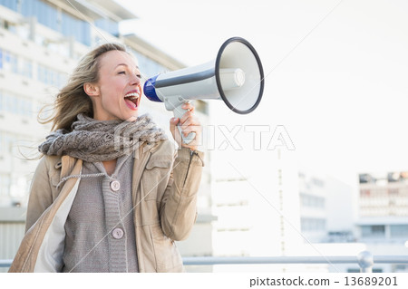 Happy blonde woman speaking on megaphone Happy blonde woman speaking on megaphone 13689201