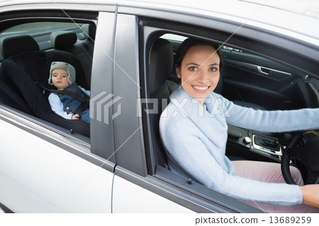 Mother driving with her baby in the car seat Mother driving with her baby in the car seat 13689259